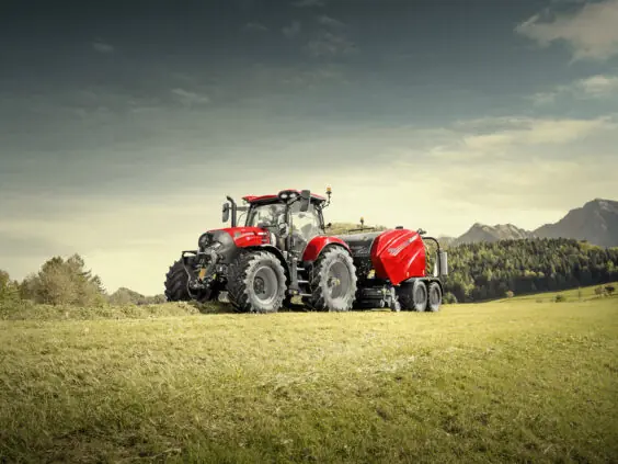 En rød traktor fra Case IH Maxxum-serien i arbeid på en gresskledd mark.