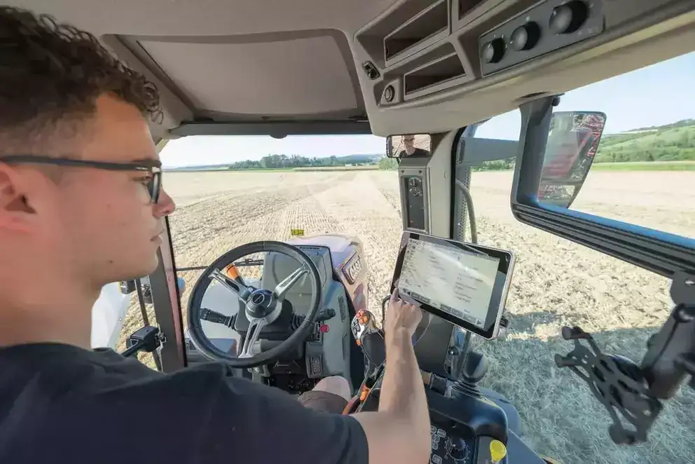 Fører bruker kontrollskjerm i førerhuset på en traktor fra Case IH Maxxum-serien.