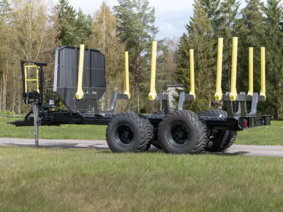 En robust PALMS 11UX tømmervogn med gule staker parkert på en gressplen.