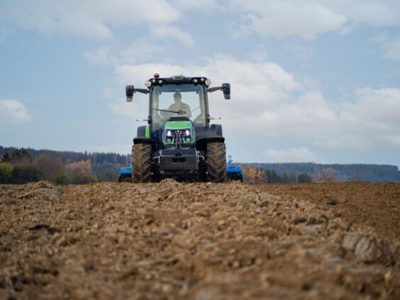 En grønn Deutz-Fahr Series 5D TTV traktor som arbeider på en åker.