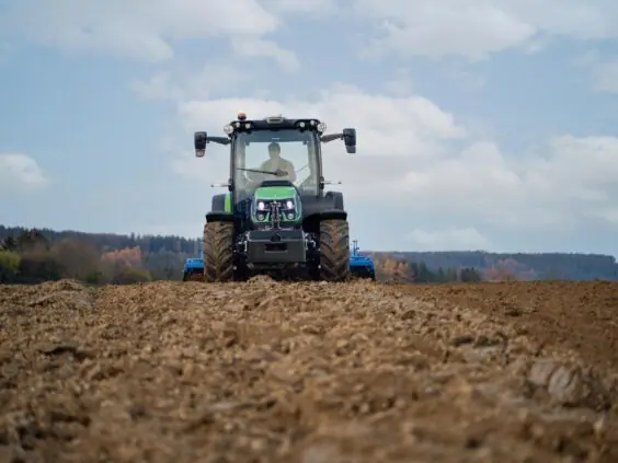 En grønn Deutz-Fahr Series 5D TTV traktor som arbeider på en åker.