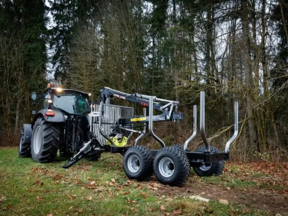 Traktor med en PALMS 3.67 skogskran montert på tømmervogn i en høstskog.