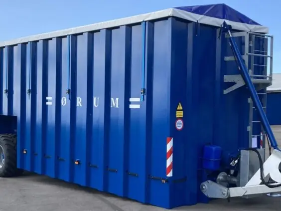 Blå ØRUM Buffertank 120 for effektiv gjødseltransport parkert på asfalt under en klar himmel.