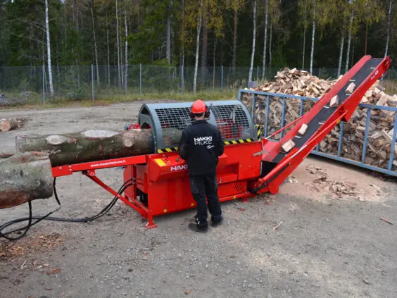 En operatør som bruker Hakki Pilke 43 Pro vedmaskin til å kappe tømmerstokker.