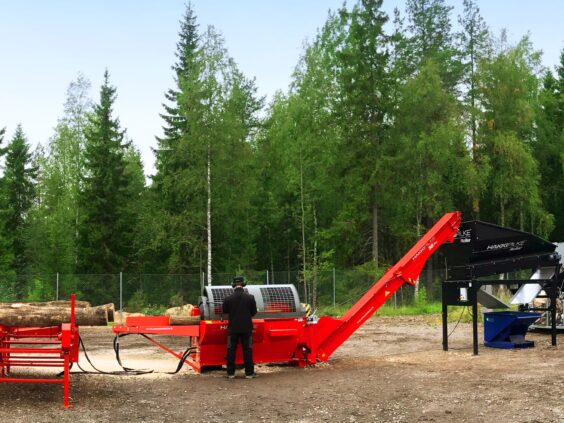 En operatør som bruker Hakki Pilke 38 Pro vedmaskin i et skogsområde.