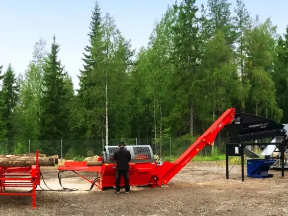 En operatør som bruker Hakki Pilke 38 Pro vedmaskin i et skogsområde.