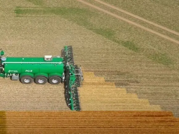 Grønn traktor med SAMSON TS-serien enkeltskjærsnedfeller i arbeid på en åker sett ovenfra.