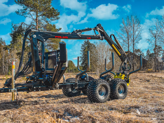 Robust PALMS 2D tømmervogn utstyrt med hydraulisk kran, plassert i et åpent skogslandskap.