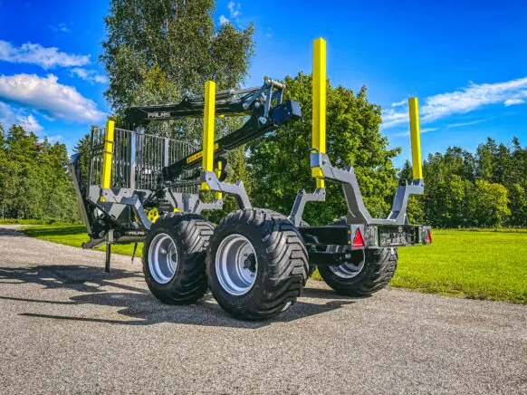 En robust PALMS 8D tømmervogn med kran parkert på en vei i fint vær.
