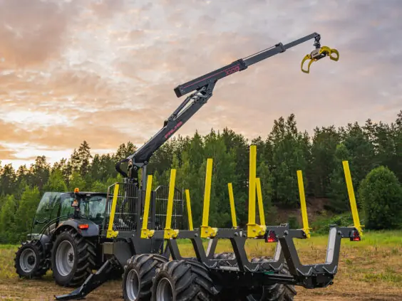 PALMS MWD 3.2 tømmervogn montert på traktor under en fargerik kveldshimmel.