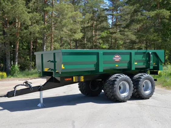 Grønn Palmse PT1900MB dumperhenger parkert på asfalt med skog i bakgrunnen.