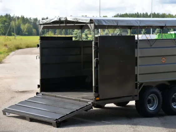 En solid PT4650 dyrehenger med åpen rampe og grå presenning utendørs.