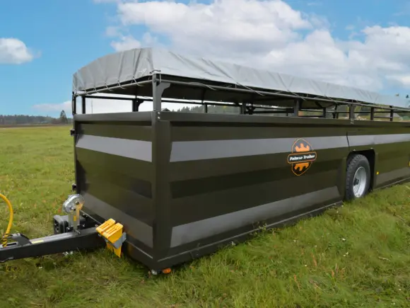 Palmse Trailer PT4800-HS dyrehenger på en grønn eng under en blå himmel.