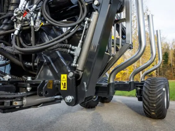 Nærbilde av detaljer og hydraulikk på en PALMS 7.94 skogskran montert på tømmervogn.