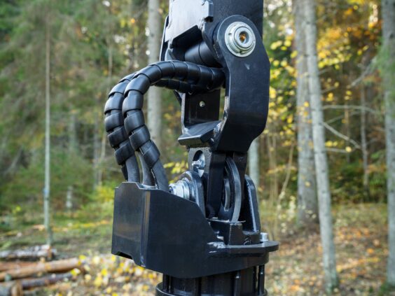 Nærbilde av hydrauliske koblinger og ledd på en PALMS 7.94 skogskran i skogen.