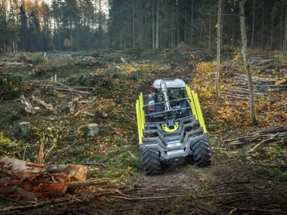 En traktor med PALMS 7.94 skogskran på en hogstflate i skogen.