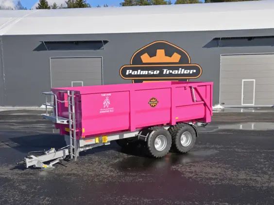 En rosa Palmse PT1620L-MB tilhenger parkert foran en stor grå hall.
