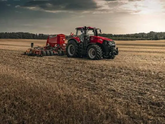 Case IH Magnum med såmaskin på åker i solnedgang