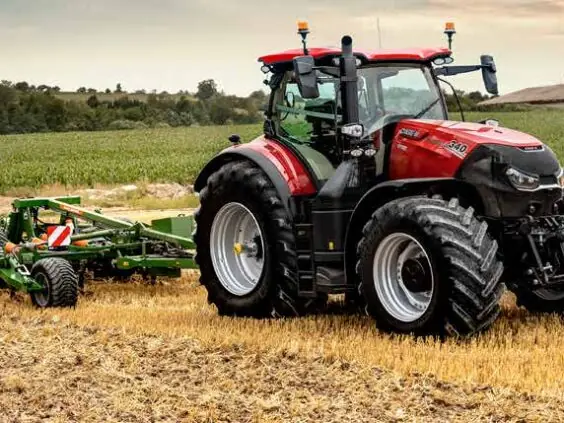 Case IH Optum 340 med harv på stubbåker ved en gård