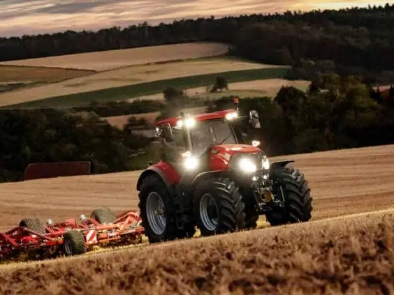 Case IH Optum med harv i kupert terreng i kveldslys