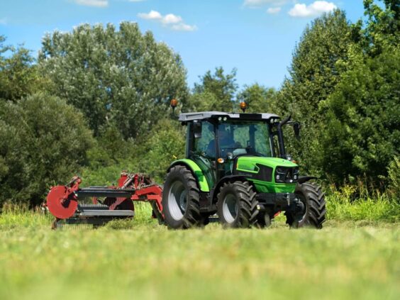 En grønn Deutz-Fahr 5D Keyline traktor som arbeider på en mark med landbruksutstyr.