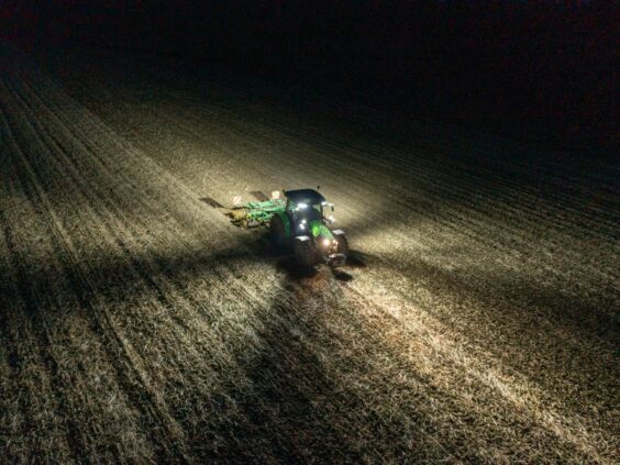 Deutz-Fahr Series 5 traktor i arbeid på mørk åker med kraftig belysning om natten.