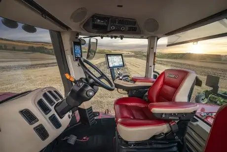 Interiøret i førerhuset på en Steiger 785 Quadtrac traktor med utsikt over åkeren.