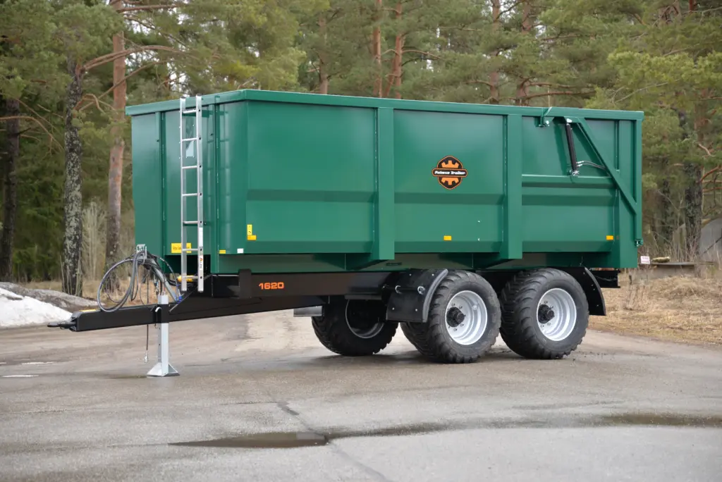 Grønn Palmse PT1620L-MB dumperhenger parkert på asfalt foran en skog.