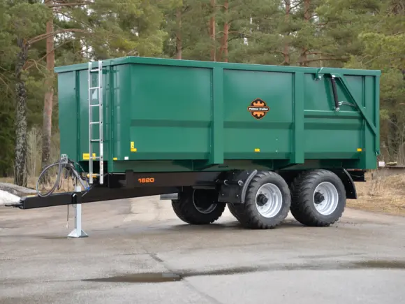 Grønn Palmse PT1620L-MB dumperhenger parkert på asfalt foran en skog.