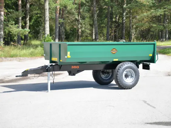 Grønn Palmse PT350D tilhenger parkert på asfalt med skog i bakgrunnen.