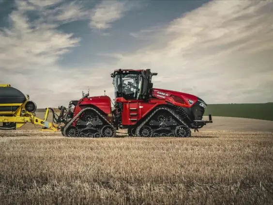 En rød Case IH Steiger 785 Quadtrac traktor med belter på en innhøstet åker.