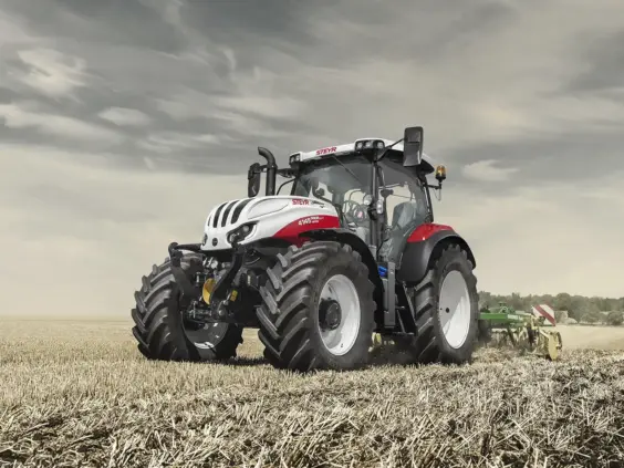 Steyr Profi CVT traktor i arbeid på en stubbeåker under en overskyet himmel.
