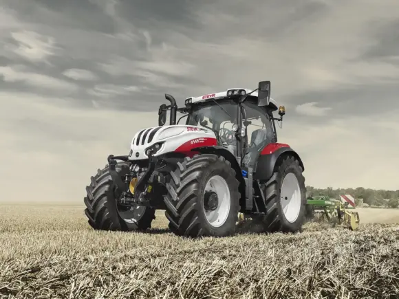 Steyr Profi CVT traktor i arbeid på en stubbeåker under en overskyet himmel.