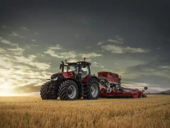 Rød Case IH traktor fra Optum-serien på en åker i dramatisk kveldslys.