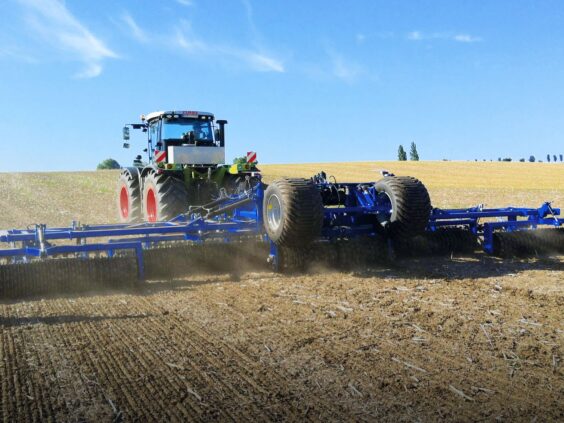 En traktor trekker en DALBO Maxiroll HD (Heavy Duty) 3-delt systemtrommel på et jorde.