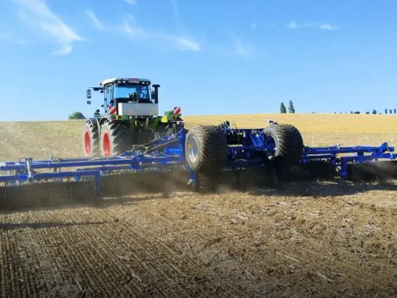 En traktor trekker en DALBO Maxiroll HD (Heavy Duty) 3-delt systemtrommel på et jorde.