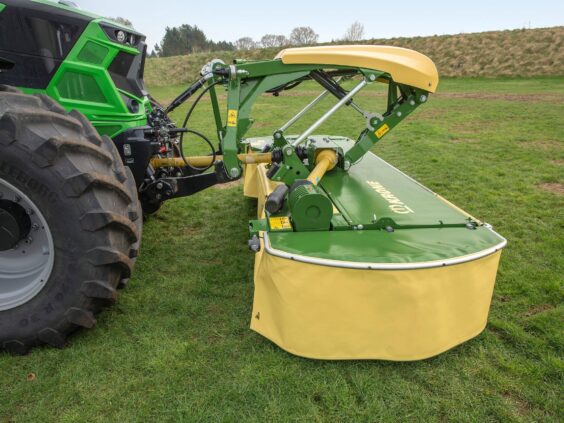 Grønn traktor med Krone EasyCut F 280 – F 320 frontslåmaskin på en gresslette.