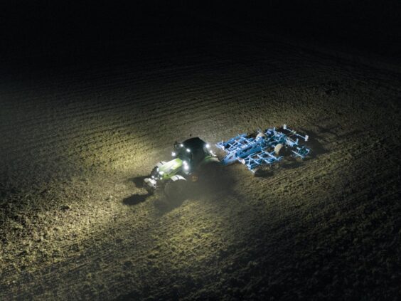 Luftfoto av en Deutz-Fahr Series 7 traktor som arbeider på en åker om natten.
