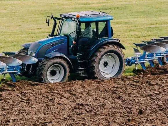 Traktor med Överum Xcelsior FX-H frontplog og bakmontert plog i arbeid