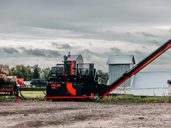 En robust Palax C900.2 vedmaskin klargjort for kapping og kløyving av tømmer utendørs.