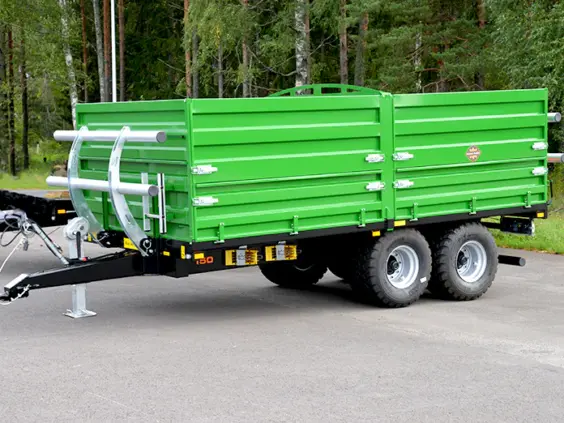 Grønn Palmse Trailer PT150 kornhenger på en asfaltert vei med skog i bakgrunnen.