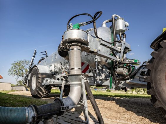 Nærbilde av Pichon fyllesystemer for vakumvogner montert på en stor galvanisert tankvogn ute i felt.