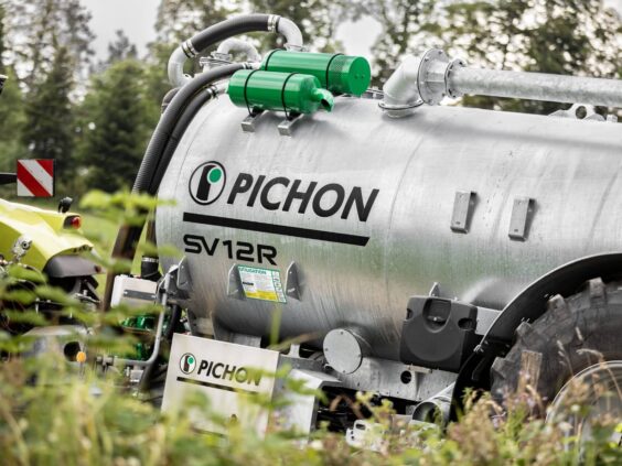 En galvanisert Pichon SV-serien vakumvogn på en gård med en traktor i bakgrunnen.