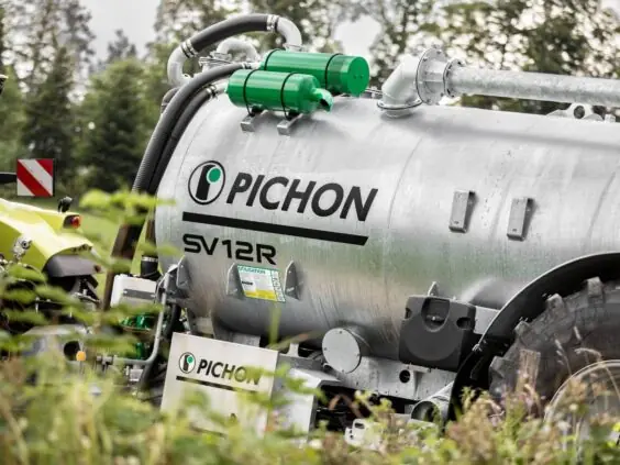 En galvanisert Pichon SV-serien vakumvogn på en gård med en traktor i bakgrunnen.