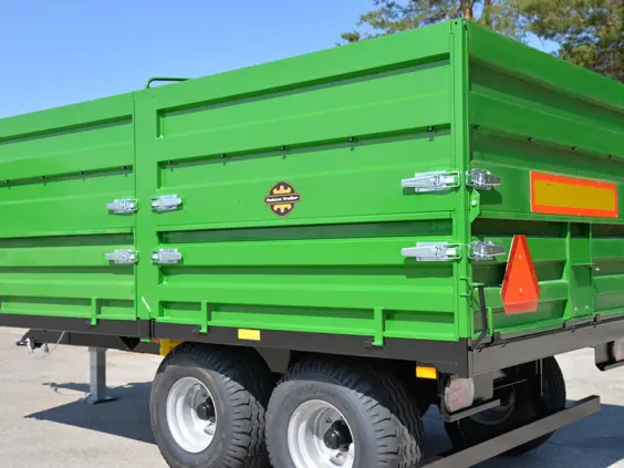 Grønn Palmse Trailer PT125 kornhenger parkert utendørs på en solrik dag.