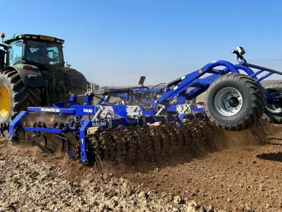 John Deere traktor som trekker en DALBO Rollomaster såbedsharv over en åker.