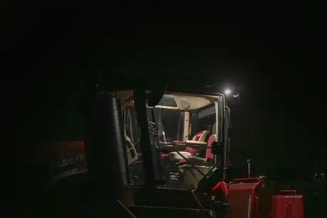 Opplyst førerhus av en Steiger 785 Quadtrac traktor i mørket.