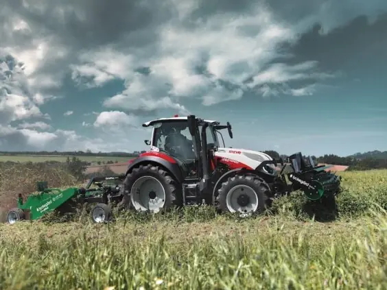 Steyr Expert 4140 med front- og bakmontert slåtteutstyr på eng