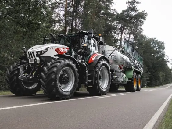 Steyr Impuls 6200 med gjødselvogn og stripespreder på landevei