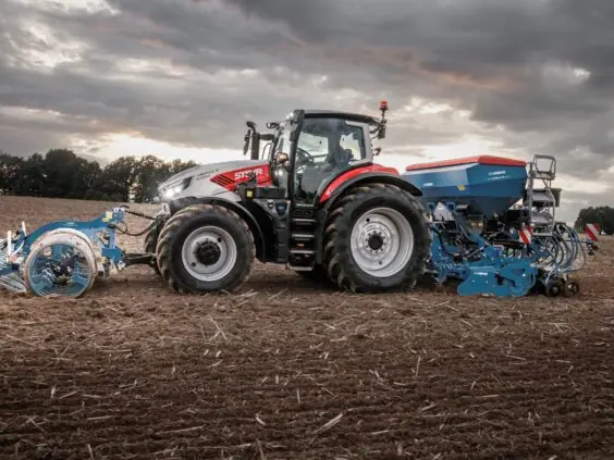 Steyr Impuls 6200 med Lemken såmaskin på stubbåker i skumringen